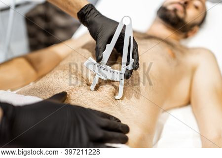 Determining The Amount Of Sebum On Male Abdomen Using Medical Caliper, Close-up
