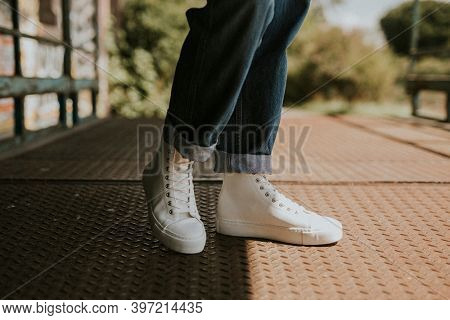 High top white sneakers on jeans model