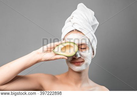 Beauty Portrait Of Smiling Brunette Woman In A Towel On The Head With White Nourishing Mask Or Creme