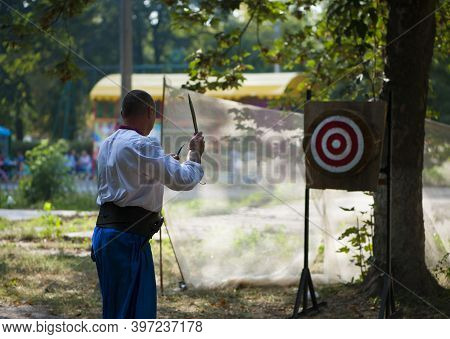 A Man Is Ready For Throwing Knife To The Target On Competition.