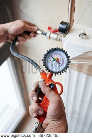 Closeup Plumber Filling Pipes With Pressurized Air To Inspect For Leaks In New Heating System Instal