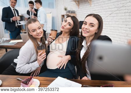 Two Young Girls Are Laughing At Work Annoying Boss. Two Women Are Standing In The Office With Papers