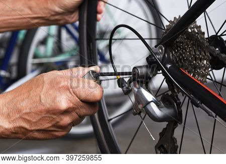 Bicycle Repair. Closeup of a bicycle derailleur and a mechanics hands making adjustments. 