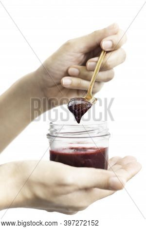 Woman Hand Holding A Spoon With Berry Jam In Jar In Clipping Path.
