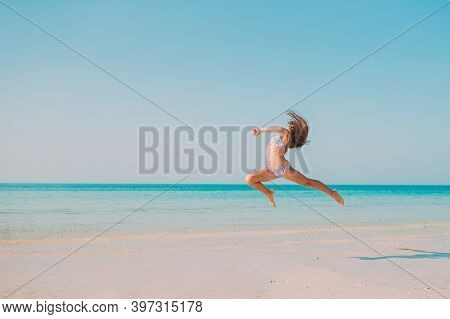 Adorable Active Little Girl At Beach During Summer Vacation