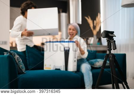 Happy Videobloggers Record Unpacking Video For Their Video Blog With A Brand New Gaming Console At H