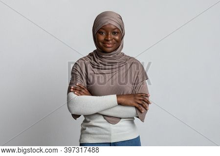 Portrait Of Confident Black Muslim Woman In Hijab Posing With Folded Arms Over Light Background, Bea