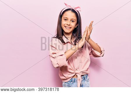 Beautiful child girl wearing casual clothes clapping and applauding happy and joyful, smiling proud hands together 