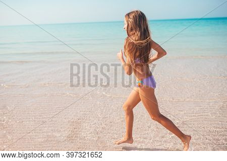 Adorable Active Little Girl At Beach During Summer Vacation