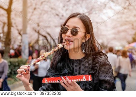 Young Woman Eating Steamed Octopus Legs At Jinhae Gunhangje Festival Street Food In Seoul, South Kor