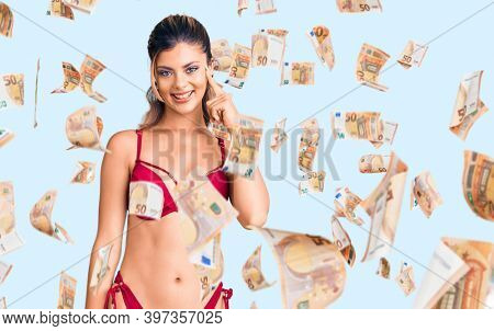 Young beautiful woman wearing bikini smiling pointing to head with one finger, great idea or thought, good memory