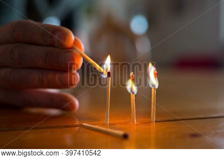Pyromaniac Man Playing With Burning Matches On Pine Wood Table.