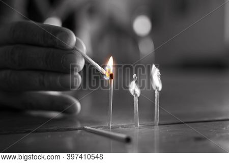 Desaturated Image, Pyromaniac Man Playing With Burning Matches On Pine Wood Table.