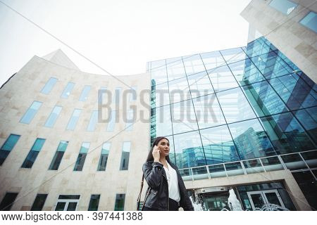 Woman talking on mobile phone outside the office premises