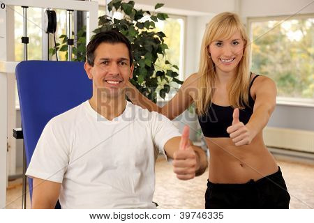 attraktive blonde Frau und ihr Trainer in einem Fitnessstudio