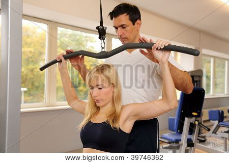 attraktive blonde Frau und ihr Trainer in einem Fitnessstudio