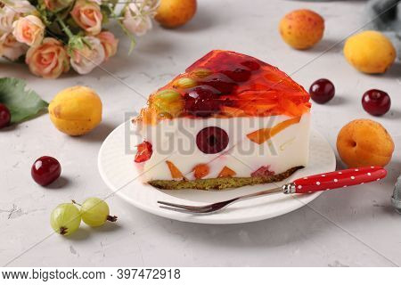 Slice Of Delicious Jelly Cake With Fruits And Berries On A Plate On A Gray Background. Closeup. Hori