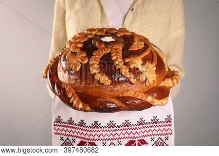 Woman With Korovai On Grey Background, Closeup. Ukrainian Bread And Salt Welcoming Tradition