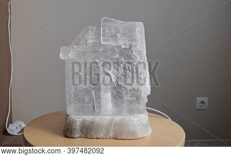 Monocrystalline Table Salt Lamp On A Wooden Stand.