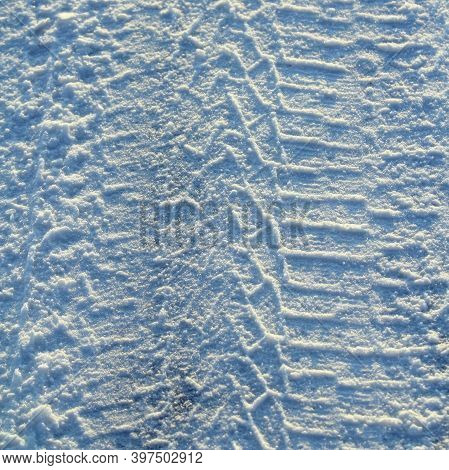 Tire Tracks Left In The Snow On A Bright Sunny Day. The Concept Of Snow Removal, Ski Resorts, Active