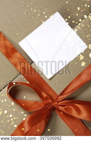 Wrapped Kraft Square Box Gift Box With Red Ribbon Bow, Vintage Style With Orange Festive Lights