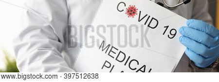 Infectious Disease Doctor Holding Covid 19 Document Medical Plan Closeup. Postpandemic Health Develo
