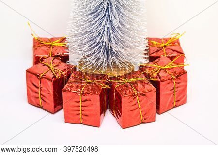 Red Gift Boxex Under The Silver Blue Fir Tree Isolated On White Background. Happe New Year And Marry