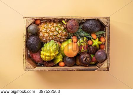 Fresh Exotic Fruits In Wooden Box Top View. Fruit Dragon, Papaya, Maracuya, Kiwi, Mango, And Granadi