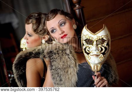 Beautiful Retro Woman With Mask Near The Mirror. Old Fashioned Vintage Makeup And Wavy Hairstyle. Ho