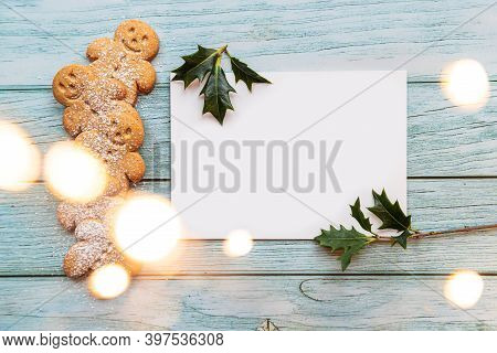 Gingerbread Cookies, Gingerman, Arranged On A Blue Table With Holly, Traditional Christmas Plant, Ch