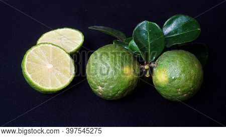Kaffir Lime Or Citrus Hystrix. Some Are Whole, Some Have Been Sliced. Focus Selected, Black Backgrou
