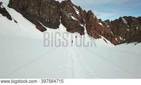 A Large Group Of Climbers Climb To The Top. A Camp Of Tents Is Set Up. Snowy Mountains In Summer. Vi