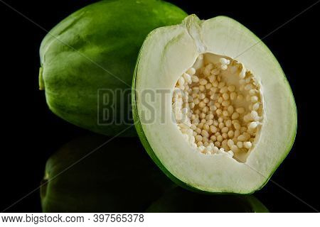 Green Round Papaya On A Black Background With Reflection.