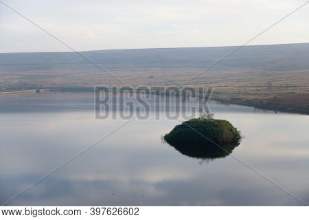 Middle Reservoir Of Redmires Reservoirs On A Calm Afternoon, Reflecting A Pale Blue Sky. Small Overg