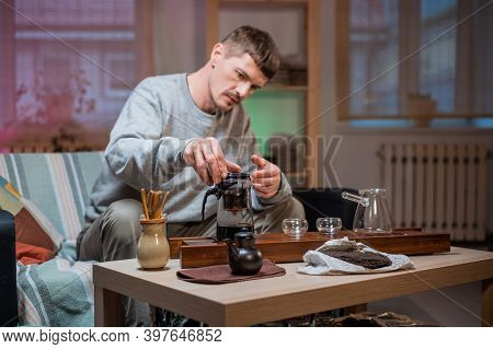 A Man Waits For Guests And Prepares Authentic Chinese Tea Using A Tea Ceremony Kit. Brews Ripe Raw T