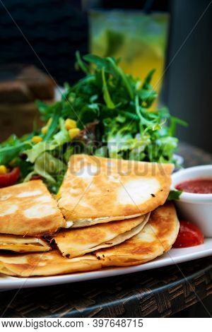 Delicious Mexican quesallidas made with chicken, tomato pieces and served with guacamole sauce.