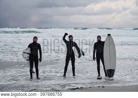 Arctic surfers going by beach after surfing