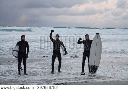 Arctic surfers going by beach after surfing