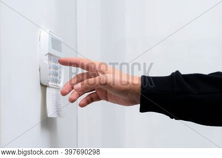 Hand Entering Alarm System Password Of An Apartment, Home Or Business Office. Surveillance And Prote