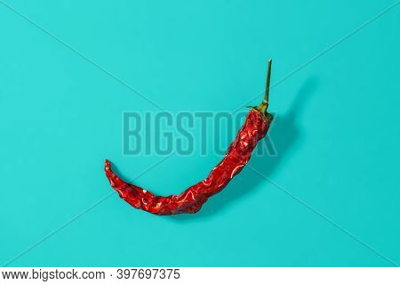 Red Hot Pepper Dry Pod Casts Shadow On A Marine Blue Background. Natural Spices And Seasonings For M