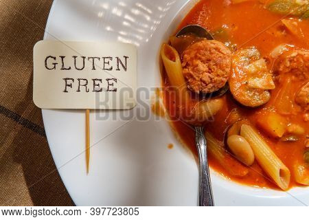 Creamy Italian Sausage Soup With Mozzarella Cheese Onions And Peppers Served With A Glass Of Red Win