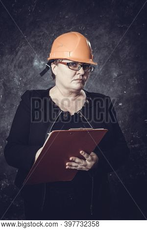 Middle-aged Woman Construction Superintendent In Helmet Studio Portrait.