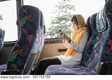 Muslim Woman With Face Mask Using Her Mobile Phone