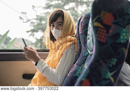 Muslim Woman With Face Mask Using Her Mobile Phone