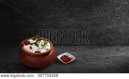 Vegetarian Meal Creamy Tasty Curd Rice With Spices Topping Served In Clay Pot And Lemon Pickle On Bl