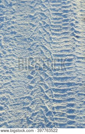 Tire Tracks Left In The Snow On A Bright Sunny Day. The Concept Of Snow Removal, Ski Resorts, Active