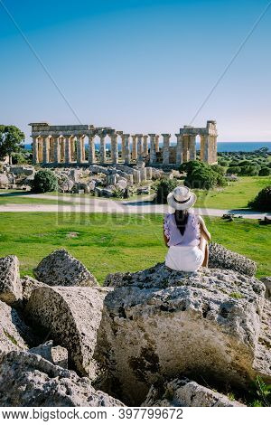 A Woman Visit Greek Temples At Selinunte During Vacation, View On Sea And Ruins Of Greek Columns In 