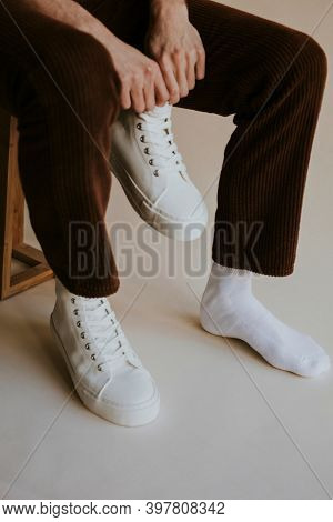 Man putting on sneaker studio shoot
