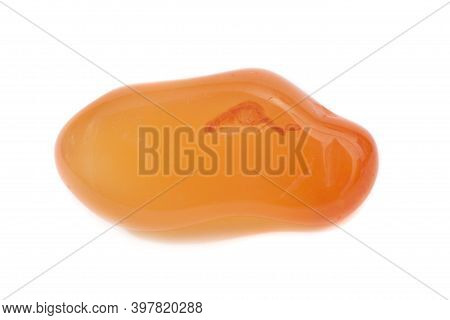 A Photograph Of An Orange Calcite Gemstone Shot Against A White Studio Background