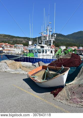 Portosin, Spain. July 3, 2020. Harbor With Galician Fishing Vessel And Old Row Boat. A Coruña Provin